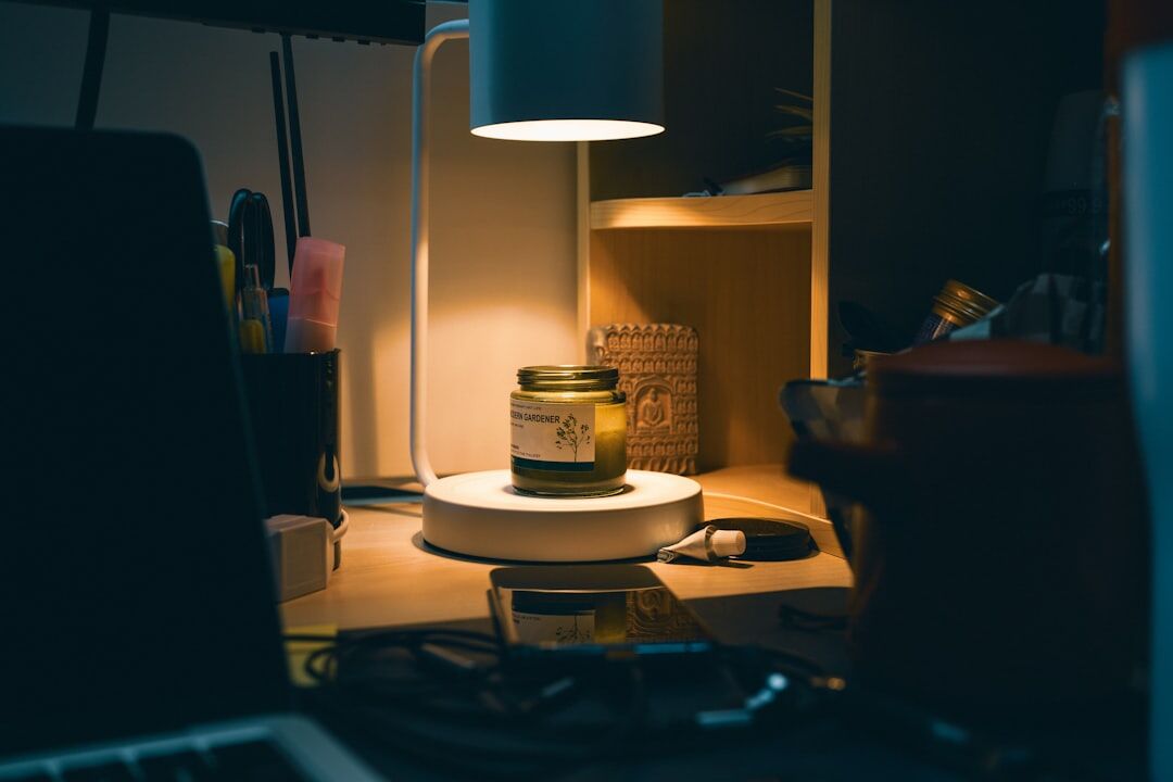 Middle-aged man writing by lamplight at a wooden desk at night